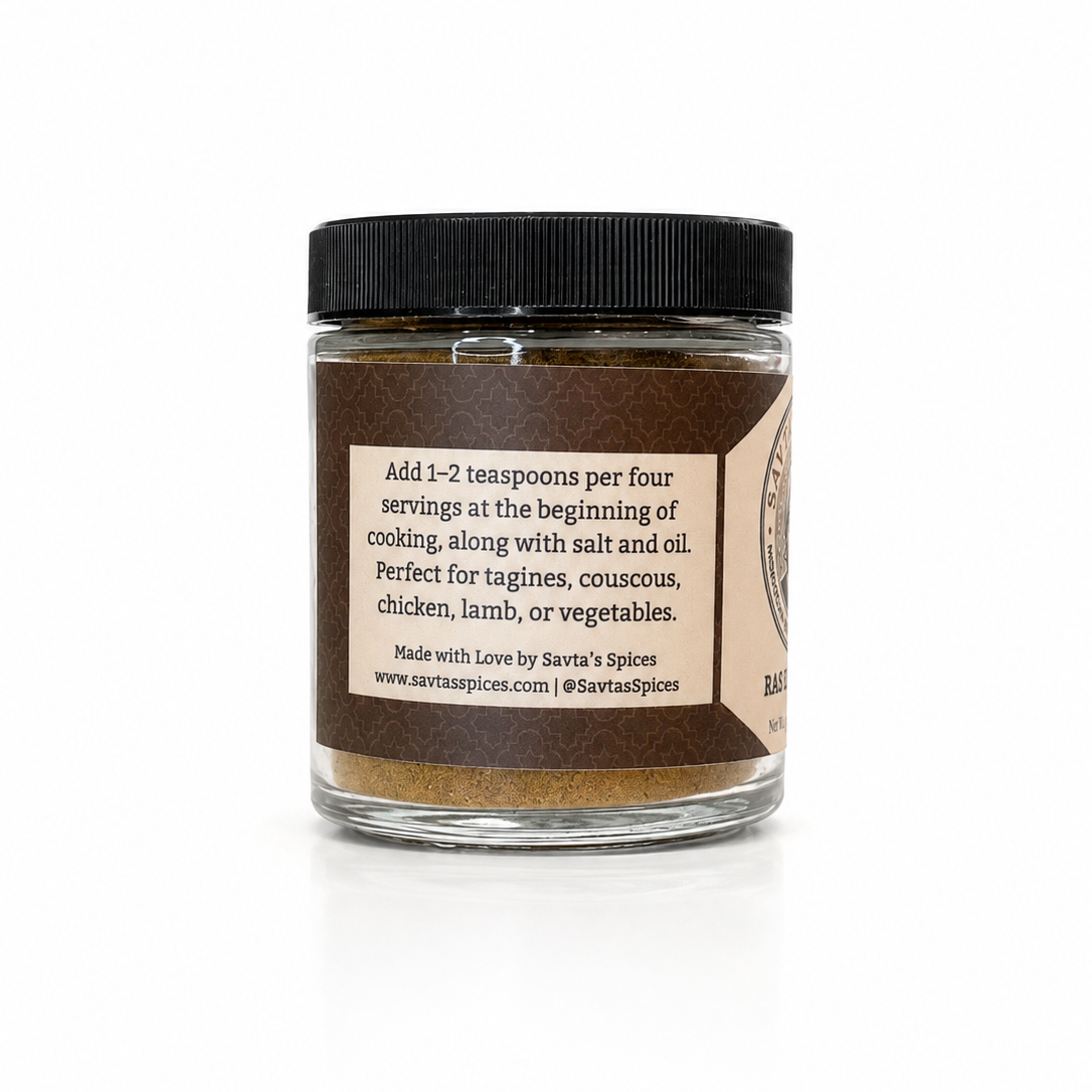 A glass jar of Savta's Spices brown spice blend with a black lid and a beige label, set against a plain white background.