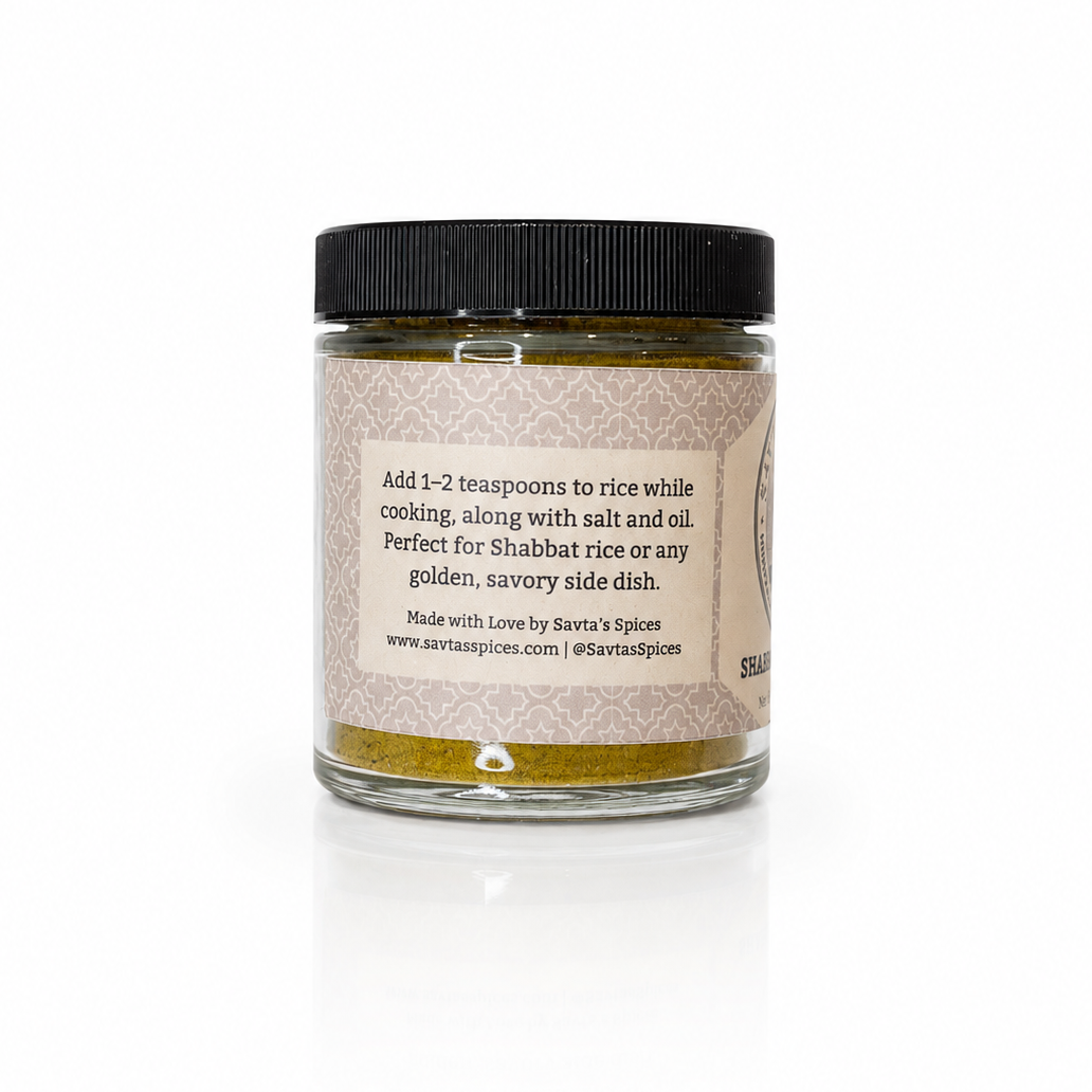 A glass jar of Savta's Spices Turmeric Spice Mix with a black lid and a textured beige label, shown on a white background with a soft reflection.